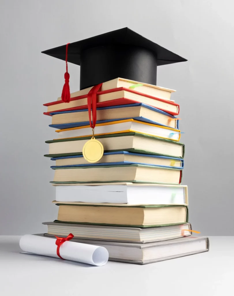 Pile de livres avec un diplôme et une toque de diplômé.