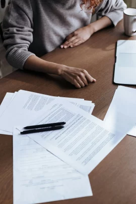Photo de documents &eacute;tal&eacute;s devant une personne : je vous aide dans vos d&eacute;marches administratives.